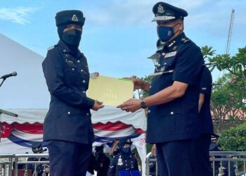 WAN Hassan Wan Ahmad menyampaikan sijil penghargaan khas kepada seorang anggota polis pada Majlis Perbarisan Sempena Peringatan Hari Polis Ke-215 Peringkat Kedah di IPK Kedah, Alor Setar hari ini. - UTUSAN/JAMLIAH ABDULLAH