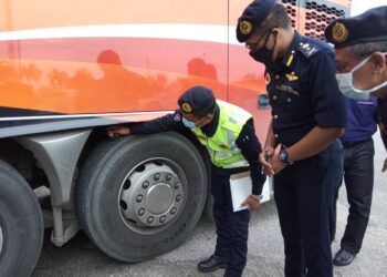 HANIF Yusabra Yusof (kanan) melihat anggotanya memeriksa tayar bas di Terminal Bas Lembah Sireh, Kota Bharu. - UTUSAN/ROSLIZA MOHAMED