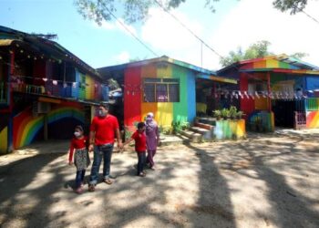 ORANG ramai bersiar-siar melewati rumah-rumah yang dicat dengan warna pelangi di Kampung Budor, Kota Bharu. - UTUSAN/ZULHANIFA SIDEK