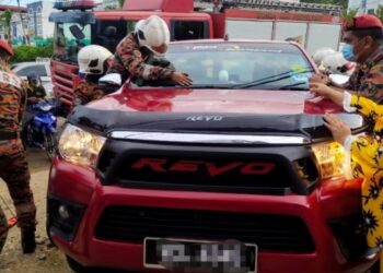 ANGGOTA bomba menggunakan peralatan khas untuk menyelamatkan kanak-kanak yang terperangkap dalam kereta terkunci dari dalam di Jalan Daeng Selili di Kuala Kangsar hari ini. - FOTO/IHSAN JBPM PERAK