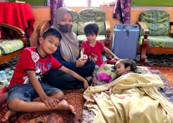 JUNIZA Ibrahim (tengah) bersama anaknya, Duranni Iman yang menghidap komplikasi sakit jantung dan jangkitan paru-paru dan Damiaa Maisarah (terlantar) menghidap kanser otak tahap empat ketika ditemui di Kampung Sungai Dua Besar, Kuala Pilah, Negeri Sembilan, semalam. – UTUSAN/ZAKKINA WATI AHMAD TARMIZI