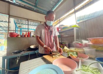 ABDUL Karim Tin yang tidak dapat membuka kantin sekolah ketika ini hanya menolong di kedai makan
anak saudaranya di Kampung Guar Syed Alwi, Kangar, Perlis.– UTUSAN/NAZLINA NADZARI