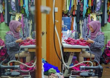 RAMLAH Ibrahim tekun menyiapkan tempahan baju kurung pelanggan menjelang sambutan Aidilfitri Medan Mara, Kuala Lumpur. - UTUSAN/FARIZ RUSADIO