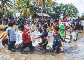 SEKUMPULAN kanak-kanak bermain kerusi muzik di dalam petak sawah ketika musim cuti sekolah di Laman Padi, Pulau Langkawi, Kedah, baru-baru ini. - UTUSAN/ SHAHIR NOORDIN