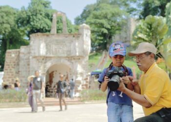 PENGUNJUNG, Samad Hassan mengajar cucunya, Caliph Ummar cara menggunakan kamera ketika melawat tapak bersejarah Kota A'Famosa atau dikenali sebagai Porta de Santiago sempena hujung minggu di Banda Hilir, Melaka. - MINGGUAN/RASUL AZLI SAMAD