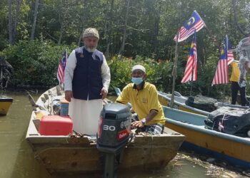 SYED Abu Hussin Hafiz Syed Abdul Fasal (kiri) bersama nelayan pada majlis penyerahan enjin sangkut kepada PNK Matang di Jeti Kampung Tebuk Matang di Bukit Gantang, Perak, semalam. - UTUSAN/WAT KAMAL ABAS