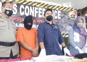 TERTUDUH (berbaju oren) ketika dibawa ke sidang akhbar selepas didakwa melakukan tindakan tidak senonoh terhadap dua anak kandungnya. - AGENSI