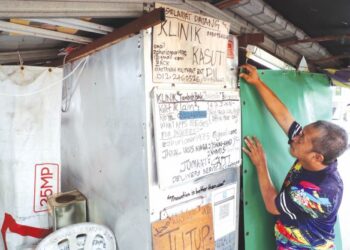 ZAHURI Omar memeriksa kedai baiki kasut miliknya di Masjid Tanah, Melaka, semalam yang sudah hampir sebulan tidak beroperasi sepanjang pelaksanaan PKP. – UTUSAN/RASUL AZLI SAMAD