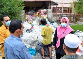 WAN Norashikin Wan Noordin (dua dari kanan) meninjau keadaan rumah seorang wanita yang dipenuhi timbunan sampah di Taman Bersatu, Simpang Pulai, Ipoh, Perak, semalam. – UTUSAN/ZULFACHRI ZULKIFLI