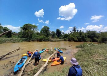 AZHAR Jaafar (duduk, kanan) bersama rakan-rakannya menemukan beberapa kayak yang hanyut dalam banjir kilat di Kampung Seberang Pekan, Baling, Rabu lalu. - UTUSAN/NORLIA RAMLI