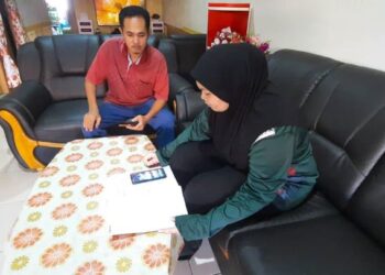 AZAHARI Mahamad (kiri) menemani anaknya, Ain Hizatti Azahari mengikuti sesi PdPR walaupun capaian internet yang lemah di Taman Lagenda, Padang Serai, Kulim, Kedah, semalam. – FOTO/AZAHAR HASHIM