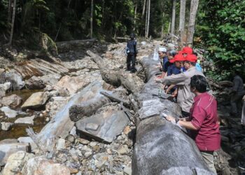 TAKIYUDDIN Hassan (tiga dari kanan) melihat lokasi pemasangan EWS di Titi Hayun yang terletak di kaki Gunung Jerai, Yan di sini.