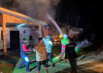 ANGGOTA bomba memadam api yang marak di rumah Mohd. Zarani Abu Seman dalam kebakaran di Kampung Teloi Tua, Sik, Kedah, petang semalam. – FOTO/NORLIA RAMLI