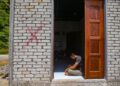 YUSUF Mohamad termenung di rumahnya yang ditanda dengan cat merah yang akan dirobohkan di Kampung Baru, Bukit Malut, Langkawi, Kedah. - UTUSAN/ SHAHIR NOORDIN