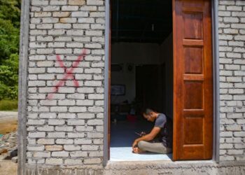 YUSUF Mohamad termenung di rumahnya yang ditanda dengan cat merah yang akan dirobohkan di Kampung Baru, Bukit Malut, Langkawi, Kedah. - UTUSAN/ SHAHIR NOORDIN