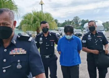 BURHANUDDIN Hussain (dua kanan) diiringi polis ketika dihadapkan ke Mahkamah Majistret akibat perbuatan khianat mencantas bendera parti politik di Kompleks Mahkamah Alor Setar.