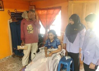 SHAFIANPANDI Zainul (kiri) bersama anak perempuannya yang kemalangan tidak dapat menahan perasaan sedih ketika menerima pampasan di bawah SKSSR yang dicarum arwah isteri di Kampung Bahagia, Kota Sarang Semut, Alor Setar, Kedah. -UTUSAN/JAMLIAH ABDULLAH