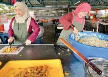 NUR Ayu Md. Yusof (kanan) dan Nur Aida mewarisi perniagaan cucur udang ibu mereka yang laris di Pokok Sena, Kedah. – FOTO/JAMLIAH ABDULLAH