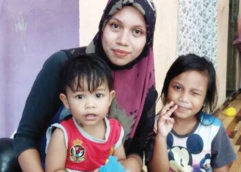 SITI Fathihah Zaional meriba Fatih Zulkarnain Mohd. Zuhairi yang mempunyai masalah jantung sambil ditemani Nur Syasya Qistina Mohd. Zuhairi di Kampung Teluk Pendiat, Baling hari ini. - UTUSAN/NORLIA RAMLI