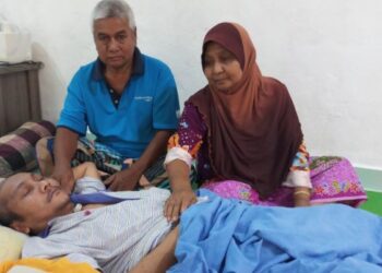 BAKAR Taib (kiri) dan isterinya, Hamtiah Chik di sisi anak mereka, Hasrolnizan yang menderita kanser otak tahap empat di rumah mereka di Kampung Bukit, Kuala Kuang, Kupang, Baling. – FOTO/NORLIA RAMLI
