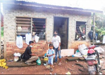 MUHAMMAD Ridwan Tee Abdullah (kiri) bersama isteri, Rahimah Abd. Razak dan salah seorang anak, Muhammad Fazrin Danish di hadapan rumah mereka yang ditumpang di Kampung Kilang Makau, Pokok Asam, Sungai Petani, Kedah, semalam. - FOTO/OTHMAN YAHAYA