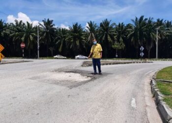 AZAHARI Mahamad menunjukkan jalan yang berlubang di simpang masuk Jalan Taman Puteri, Padang Serai, Kulim, Kedah, semalam. - FOTO/AZAHAR HASHIM
