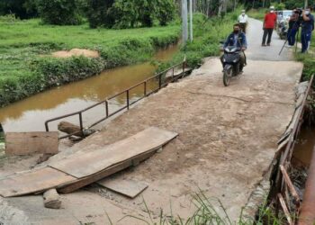 PENDUDUK terpaksa menggunakan jambatan yang rosak di Kampung Parit, Mukim Tualak, Kuala Nerang, Padang Terap, Kedah. - UTUSAN/MOHD. RIFAAT ABD. HAMID