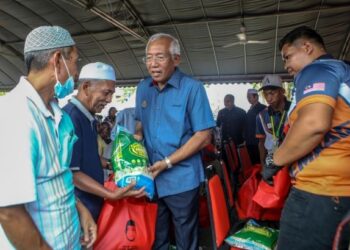 MAHDZIR Khalid (tengah) menyampaikan sumbangan kepada penduduk kampung ketika menghadiri Program Komuniti Sejahtera Bukit Tembaga di Kuala Nerang hari ini.- UTUSAN/ SHAHIR NOORDIN