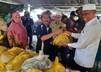 WAN Romani Wan Salim (kanan) mewakili KPDNHEP Kedah menjual minyak masak kepada pengguna semasa merasmikan Program Jelajah Kepenggunaan Peringkat Negeri Kedah di Dewan Al- Amin, Telok Bagan, Alor Setar, Kedah.
