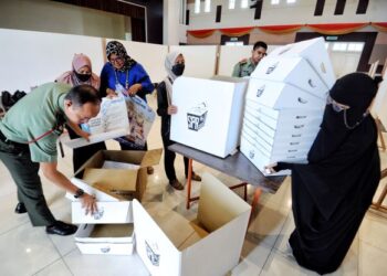 PARA petugas membuat persiapan hari pengundian awal PRU15 di Dewan Serbaguna Kem Segenting, Port Dickson, Negeri Sembilan. - UTUSAN/MOHD. SHAHJEHAN MAAMIN