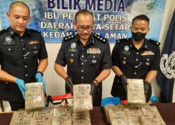 AHMAD Shukri Mat Akhir (tengah) bersama pegawainya menunjukkan ketulan mampat ganja yang dirampas dalam serbuan di Kuala Kedah, di sini, Ahad lalu.