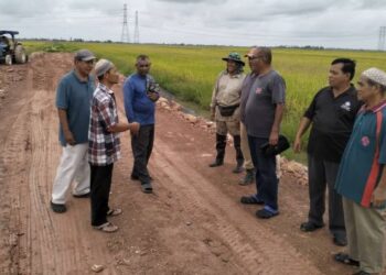 PETANI di Kampung Benua dan Kampung Kebun Pinang membincangkan nasib dihadapi mereka di atas tapak jalan yang masih belum siap bagi kemudahan mengeluarkan hasil padi.