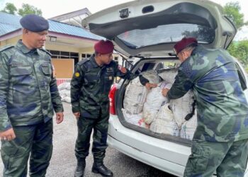 NORDIN Manan (tengah) melihat guni berisi daun ketum dalam sebuah kenderaan yang cuba diseludup di Markas Taktikal PGA Bukit Kayu Hitam, Kubang Pasu, Kedah, hari ini. - FOTO/JAMLIAH ABDULLAH