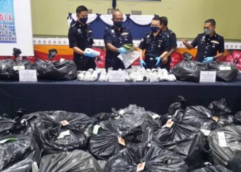 ANUAR Abdul Rahman (dua dari kiri) menunjukkan sebahagian daun ketum yang dirampas daripada dua lelaki pada sidang akhbar di IPD Kuala Muda, Sungai Petani, Kedah, hari ini. - FOTO/OTHMAN YAHAYA