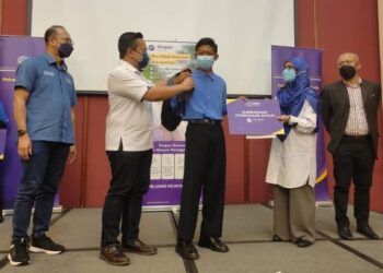 WAN Saiful Wan Jan (dua dari kiri) membantu seorang pelajar menggalas beg pada Program Jelajah Simpan SSPN 2022 di Langkawi hari ini. - FOTO/NUR AMALINA AZMAN