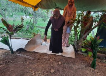 SALMAH Aminudin menyiram air mawar pada pusara arwah ibunya yang dikebumikan di Tanah Perkuburan Islam di Masjid Al Muhtadin, Kampung Budi , Pokok Sena, Kedah. - UTUSAN/MOHD RIFAAT ABD HAMID