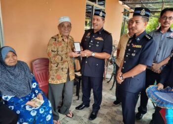 MOHD. Ali Saad (dua dari kiri) menerima Pingat Jasa Pahlawan Negara daripada Mulkiaman Manzar yang berkunjung ke rumah bekas anggota polis itu di Kampung Baharu, Kuala Nerang, Kedah. - MINGGUAN/MOHD. RIFAAT ABD HAMID