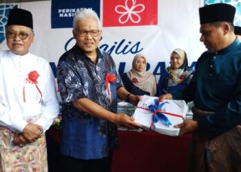 HAMZAH  Zainuddin (dua dari kiri) menerima borang keahlian ahli Bersatu daripada Ketua Bahagian Bersatu Baling, Mohd. Taufik Yaakob (kiri) pada Majlis Kenduri Raya Bersatu di Dataran Pejabat Bersatu, Batu 42, Baling, Kedah, hari ini. - FOTO/NORLIA RAMLI