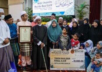 ABDULLAH Lebai Samah (empat dari kiri) bersama ahli keluarganya selepas menerima Anugerah Tokoh Maulidur Rasul sempena Majlis Sambutan Maulidur Rasul Peringkat Negeri Kedah, di Alor Setar, Kedah. -UTUSAN/SHAHIR NOORDIN