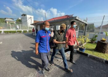 PEGAWAI penguat kuasa KDN mengiringi Ammar Abdullah (tengah) untuk dibicarakan di Mahkamah Majistret Tumpat, Kelantan.