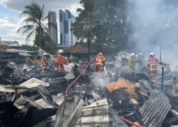 ANGGOTA bomba memadamkan kebakaran kawasan setinggan di Jalan Klang Lama hari ini.
