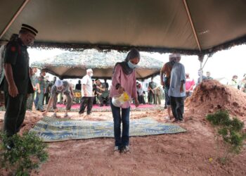 NOR Aqila Syafiqa Safuan menyiram air mawar di atas pusara  Allaharyam Mohamad Azrin Mohamad Isa  di Tanah Perkuburan Islam Kampung Pinang Dalam, Laguna, Sungai Petani, Kedah. - UTUSAN/SHAHIR NOORDIN