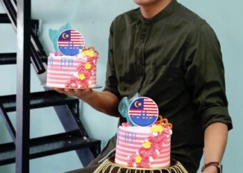 Hazwan Najib Mullah Mohd. bersama kek hari jadi bertemakan Jalur Gemilang yang ditempah oleh pelanggan pada hari kebangsaan.