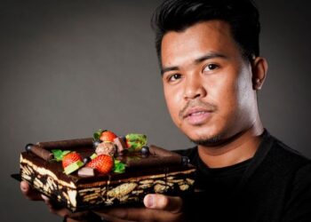 Nik Mohd. Shariff Nik Abdul Ramahan  bersama kek batiknya.