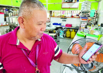 ROSMAN Ahmad melihat gambar kenangan majlis pernikahan Allahyarham Hajar Nursyahirin dan suaminya, Amir Adam ketika ditemui di Johor Bahru, semalam.