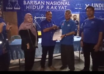 AHMAD Said (tiga, kanan) menerima borang keahlian UMNO daripada Azman A. Ghani di Kampung Ranggon, Kemasik, Kemaman, malam tadi. - UTUSAN/NIK NUR IZZATUL HAZWANI NIK ADNAN
