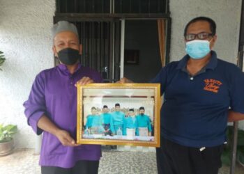 AZHAR Mohamad (kanan) dan Wan Hamizi Wan Kadir (kiri) menunjukkan gambar Perdana Menteri, Datuk Seri Ismail Sabri Yaakob dan adik beradiknya di Kampung Kampung Bukit Tingkat di Temerloh, Pahang. - FOTO/SALEHUDIN MAT RASAD