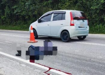 KEADAAN mangsa maut apabila motosikal ditunggang bergesel dengan sebuah lori dalam kejadian di Jalan Dengkil - Air Hitam, Selangor. - GAMBAR IHSAN IPD SEPANG