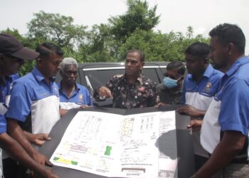 M. SARAVANAN (tengah) melihat lakaran projek pembangunan Rumah Kelab Bell Belia Tamil pada majlis Pecah Tanah Majlis Pecah Tanah Rumah Kelab Bell Belia Tamil Gopeng di Gopeng, Perak, hari ini. - UTUSAN/LIYANA RAMLI