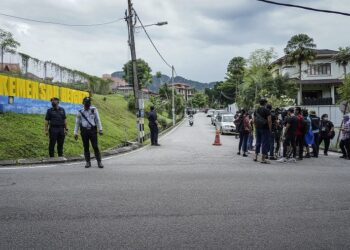 PETUGAS media menunggu perkembangan terkini di jalan masuk ke kediaman penduduk yang terlibat dalam kejadian tanah runtuh di Jalan Kemensah Height, Ampang, Selangor. - UTUSAN/ FARIZ RUSADIO